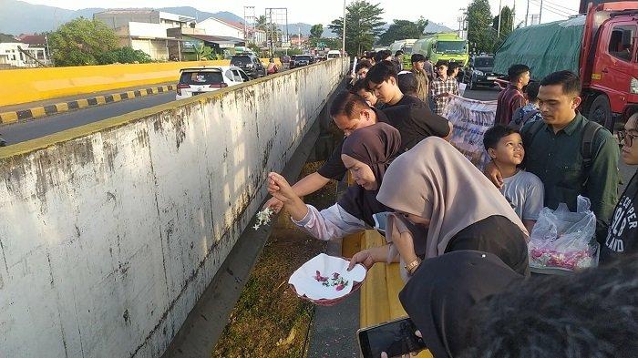 AKSI TEATRIKAL : Sejumlah massa menggelar aksi teatrikal tabur bungan untuk mengingat almarhum Afif Maulana di jembatan Bypass Kuranji, Kota Padang, Selasa (24/6/2025). Aksi tersebut dilakukan untuk mengingat satu tahun kepergian Afif Maulana.