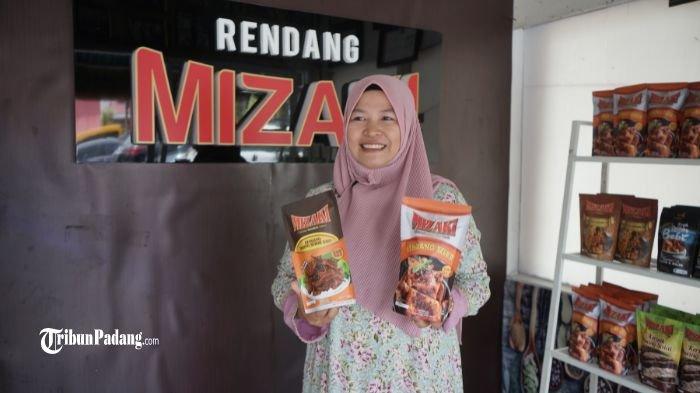 Pemilik Rendang Mizaki berpose di kedainya di Padang Panjang memegang kemasan rendang produknya, Jumat (23/6/2023)