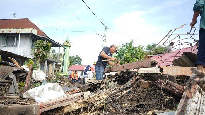 Jhoni Wismar bersama saudaranya sedang memisahkan trali besi dari Kunsen jendela, yang merupakan puing dari rumahnya setelah habis dihantam banjir di Galuang, Sungai Puar, Agam, Sumatera Barat, Selasa (14/5/2024).