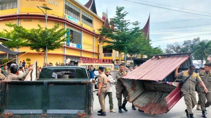 PENERTIBAN PEDAGANG- Petugas Satpol PP Kota Pariaman bersama TNI/Polri melakukan penertiban pada 26 pedagang yang berjualan di trotoar dan bahu jalan. Penertiban berlangsung dengan mengangkat sejumlah infrastruktur milik pedagang yang berada di fasilitas umum.