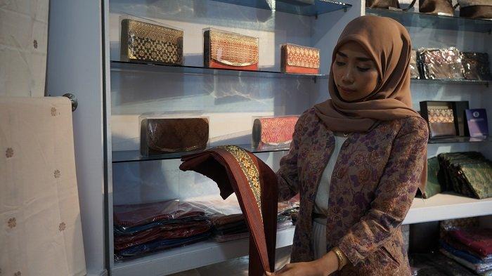Yunika Fernandes pemilik galeri Songket Tenun Minang (STM) di Jalan Bukittinggi - Payakumbuh Km 10 Ampek Angkek, Agam, sedang menunjukan produk tenun yang sudah siap, Kamis (29/6/2023).