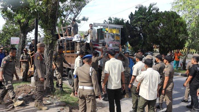 PENERTIBAN PKL PADANG - Satpol PP Padang menertibkan sejumlah lapak pedagang di Jalan Adinegoro Kecamatan Koto Tangah, Kamis (10/7/2025) pagi. Penertiban tersebut dilakukan karena masih banyak para pedagang yang berjualan di sana bahkan ada yang meninggalkan lapak-lapaknya disana.