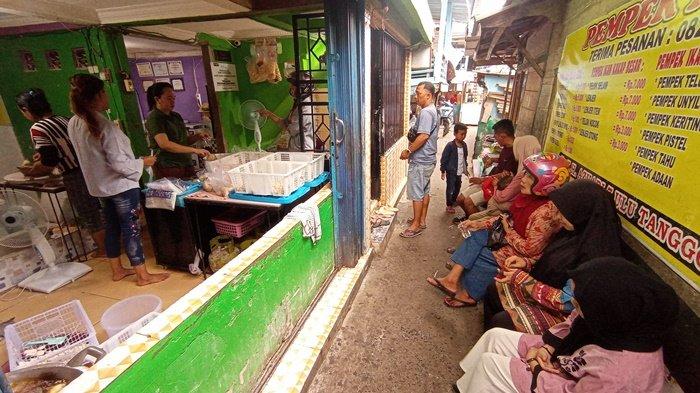 Para pembeli pempek di kampung pempek Tanggo Rajo 7 Ulu Kota Palembang antre menunggu pesanan pempeknya selesai dimasak.