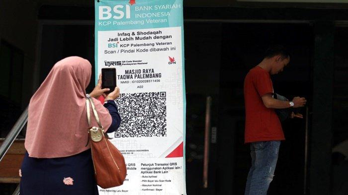 Seorang muslimah men-scan/pindai barcode Infak dan sedekah lewat QRIS BSI Mobile di depan pintu masuk Masjid Raya Taqwa Palembang, Jalan Telaga, 30 Ilir Kecamatan IB II, Kota Palembang, Rabu (16/11/2022).