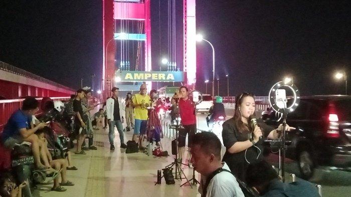 Para tiktokers Palembang saat live di trotoar Jembatan Ampera.