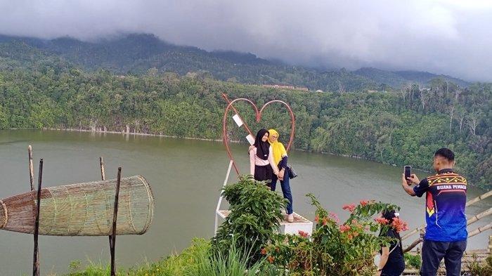 Warga berfoto di objek wisata Danau Rakihan di Desa Muara Sindang dan Ulu Danau, Kecamatan Sindang Danau, Kamis (16/11/2023).