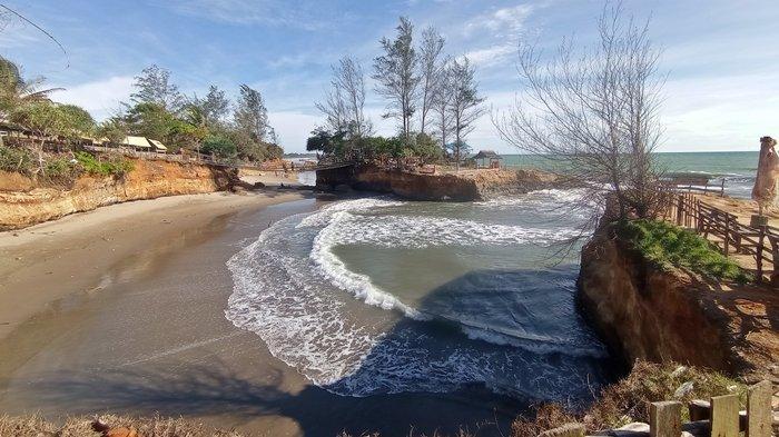Wisata melintasi jembatan gantung menuju kawasan yang mirip Tanah Lot Bali di Pantai Sungai Suci, Bengkulu, Minggu (14/1/2024).