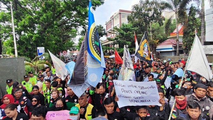 Driver ojek online (ojol) di Palembang turun ke jalan menggelar aksi damai menuntut penyesuaian tarif yang selama ini dirasa tidak adil. Aksi damai ini berlangsung di depan gerbang Kantor Gubernur Sumsel Jalan Kapten A Rivai Palembang, Senin (2/9/2024).