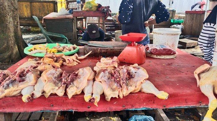 Deni (37,) salah satu pedagang pasar tradisional Kayuagung saat tengah melayani pembelinya pada Kamis (4/1/2023) sore.