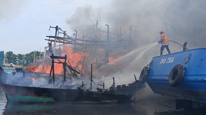 Petugas pemadaman kebakaran tampak sedang berjibaku memadamkan kapal nelayan yang terbakar di area Dok dan Galangan Kapal PT Pantai Mulia Semesta Tegal, Jumat (27/12/2024).