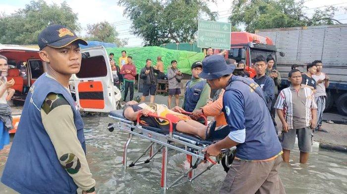 Warga penderita penyakit stroke saat dievakuasi, usai terjebak banjir di Desa Ketanjung Demak.