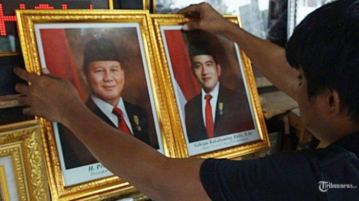 Pedagang menata bingkai foto pasangan Prabowo-Gibran sebagai Presiden dan Wakil Presiden 2024-2029 di Ali Frame Pasar Jatinegara, Jakarta Timur, Selasa (23/4/2024). Pasca-putusan Mahkamah Konstitusi (MK) yang menolak permohonan pasang calon (Paslon) presiden dan wakil presiden nomor urut 01 dan 03, kabar soal susunan kabinet Prabowo Subianto–Gibran Rakabuming Raka banyak dinantikan.
