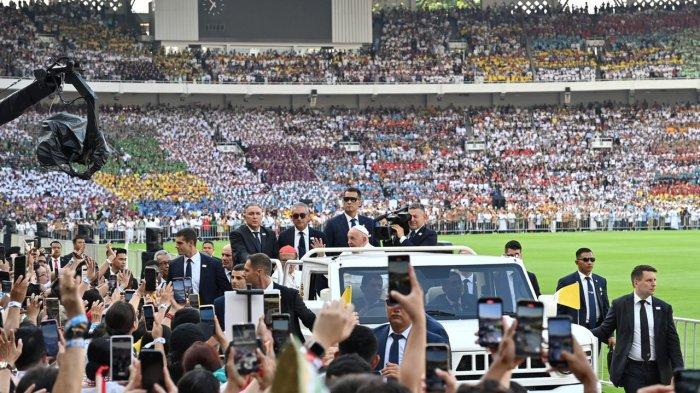 Paus Fransiskus menyapa umat Katolik yang hadir memenuhi Stadion Gelora Bung Karno (GBK), Jakarta, sebelum dimulainya perayaan ekaristi, Kamis (5/9/2024). Paus Fransiskus menaiki mobil buatan Pindad, Maung, untuk berkeliling stadion dan menyapa umat. INDONESIA PAPAL VISIT COMMITEE/RADITYA HELABUMI