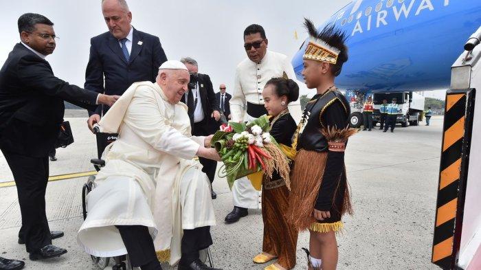 Paus Fransiskus menerima karangan bunga yang diberikan oleh dua orang anak berpakaian tradisional, Mary Lourdes Wicaksono Atmojo dan Irfan Wael setibanya di Bandara Internasional Soekarno Hatta, Tangerang, Banten, Selasa (3/9/2024). INDONESIA PAPAL VISIT COMMITTEE/ AGUS SUPARTO