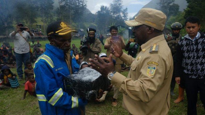 Bupati Puncak Willem Wandik saat menyerahkan dana desa kepada salah satu kepala kampung