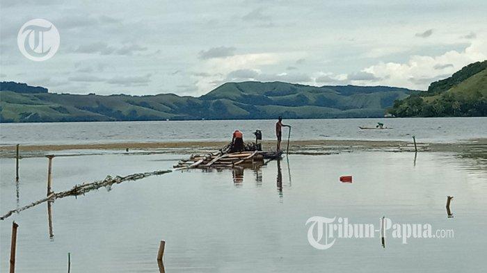 Tampak sejumlah pekerja mengeruk sedimen pasir Danau Sentani untuk dijual. Pasir dari dasar danau disedot menggunakan mesin Alkon.