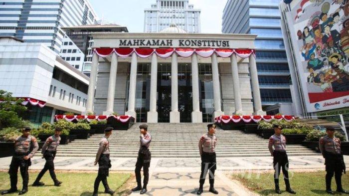 Polisi berjaga-jaga di depan Mahkamah Konstitusi (MK) menyusul kedatangan sejumlah tokoh dan akademisi serta aktivis yang memberi dukungan kepada benteng terakhir demokrasi, Kamis (22/8/2024). KOMPAS/PRIYOMBODO