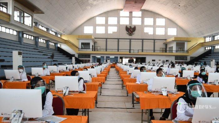 Peserta seleksi kompetisi bidang (SKB) bagi CPNS Pemkot Surabaya bersiap mengikuti tes di GOR Pancasila, Kota Surabaya, Jawa Timur, Selasa (22/9/2020). Seleksi itu menerapkan protokol kesehatan Covid-19 secara ketat, mulai dari mengenakan masker, pelindung wajah, dan sarung tangan serta jarak antar peserta tes, termasuk memisahkan peserta dengan hasil rapid tes reaktif dalam bilik khusus. Sebanyak 1.142 orang mengikuti SKB CPNS Pemkot Surabaya selama 3 hari di mana dalam satu hari terdapat 3 sesi dengan peserta sebanyak 140 orang.