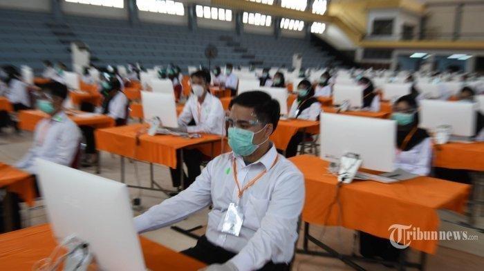 Peserta seleksi kompetisi bidang (SKB) bagi CPNS Pemkot Surabaya bersiap mengikuti tes di GOR Pancasila, Kota Surabaya, Jawa Timur, Selasa (22/9/2020). Seleksi itu menerapkan protokol kesehatan Covid-19 secara ketat, mulai dari mengenakan masker, pelindung wajah, dan sarung tangan serta jarak antar peserta tes, termasuk memisahkan peserta dengan hasil rapid tes reaktif dalam bilik khusus. Sebanyak 1.142 orang mengikuti SKB CPNS Pemkot Surabaya selama 3 hari di mana dalam satu hari terdapat 3 sesi dengan peserta sebanyak 140 orang.