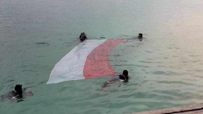 PENGIBARAN BENDERA - Ketapang Dive Community (KDC) atau Komunitas Menyelam Ketapang Manokwari mengibarkan bendera Merah Putih di bawah laut Pulau Nusrowi, Kampung Yembekiri, Distrik Rumberpoon, Kabupaten Teluk Wondama, Papua Barat, Sabtu (29/7/2023) pagi.