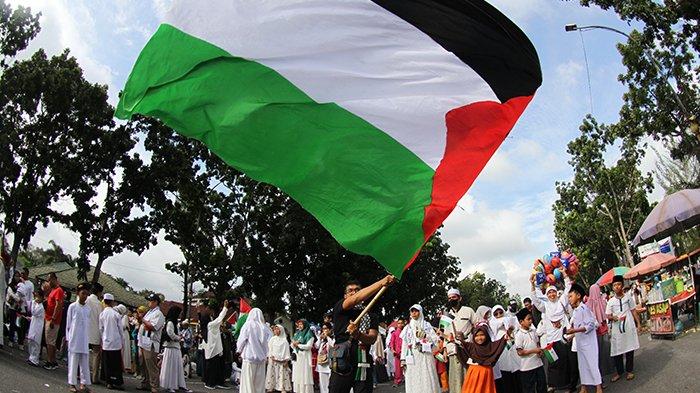 Masyarakat yang hadir dalam Aksi Pekanbaru untuk Palestina mengibarkan bendera merah putih dan bendera Palestina di Jalan Gajah Mada, Kota Pekanbaru, Minggu (19/11/2023). Tribunpekanbaru.com/Theo Rizky