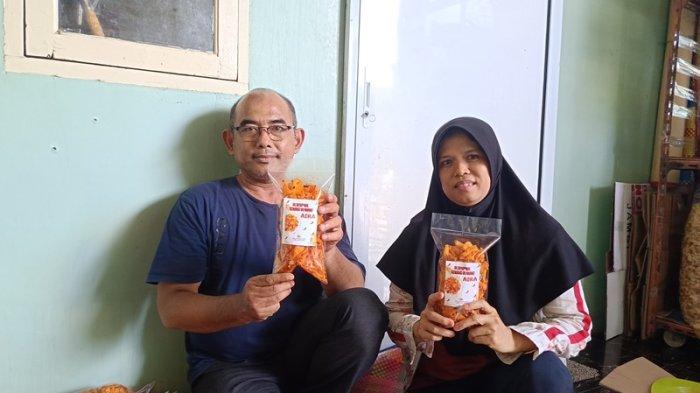 PRODUK KRIPIK SINGKONG - Ibu Elis dan suaminya memperlihatkan produk kripik singkong yang sudah dikemas dan siap dipasarkan saat ditemui di rumah sekaligus tempat usahanya di Jalan Suka Karya, Perumahan Asta Karya, Tuah Karya, Kecamatan Tuah Madani, Kota Pekanbaru, terlihat sibuk, Rabu (23/4/2025).