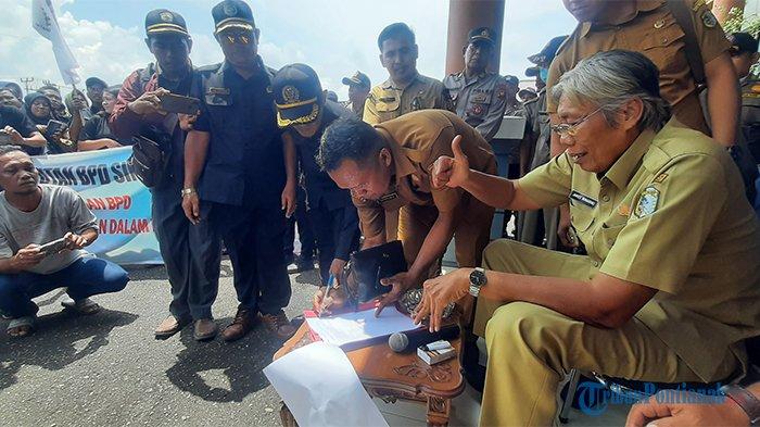 Bupati Sintang, Jarot Winarno menandatangani berita acara tiga tuntutan anggota BPD se Kabupaten Sintang. Jarot memastikan akan memperjuangkan tiga tuntutan pengurus Badan Permusyawaratan Desa (BPD) yang menggelar aksi damai di halaman Kantor Bupati Sintang, Senin 22 Mei 2023.