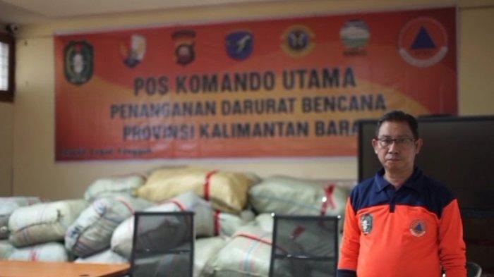 Ketua Satgas Informasi BPBD Kalimantan Barat (Kalbar), Daniel berfoto bersama sejumlah bantuan yang siap diberikan dalam penanganan bencana banjir dibeberapa wilayah di Kalbar, belum lama ini.