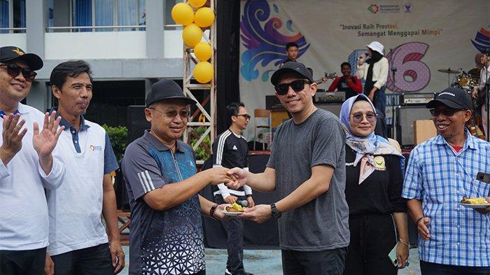 Kepala SMK SMTI Pontianak, Marwandi memberikan potongan tumpeng untuk pegawai SMK SMTI Pontianak, Senin (15/1/2024).