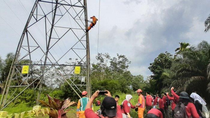 Awak media mengabadikan aksi tim PDKB UPT Pontianak, Muhammad Heru Saputra (26) memanjat tower SUTT di Jalan Kebangkitan Nasional, Kelurahan Siantan Hulu, Kecamatan Pontianak Utara, Kalimantan Barat, Kamis 14 November 2024. Tim PDKB Kalimantan Barat terpaksa memanjat tower dengan ketinggian 30 hingga 100 meter untuk membersihkan jaringan listrik yang terkena gangguan seperti tali kawat layangan.