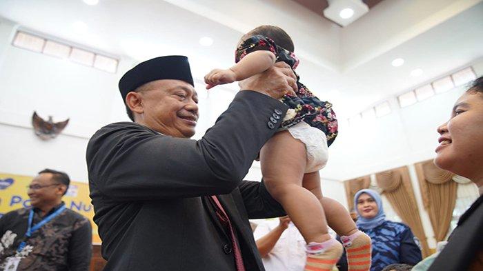 Wali Kota Pontianak 2018-2023 Edi Rusdi Kamtono menggendong seorang balita di sela acara penyerahan bantuan paket nutrisi dari sektor usaha.