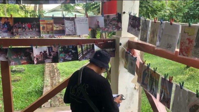 ZINE FEST - Agus, satu di antara pengunjung Pontianak Zine Fest 2025 tampak antusias membaca karya-karya zine yang dipamerkan, Sabtu 12 Julio 2025. Ia menyebut kegiatan ini membuka ruang interaksi dan diskusi seputar isu-isu lokal di Kalimantan Barat.