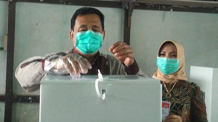 Bupati Kapuas Hulu 2010-2021 Abang Muhammad Nasir bersama istrinya Erlinawati Nasir, saat menggunakan hak pilihnya dalam pemilihan bupati dan wakil bupati Kapuas Hulu, di TPS 019 lokasi SDN 01 Putussibau, Rabu 9 Desember 2020.