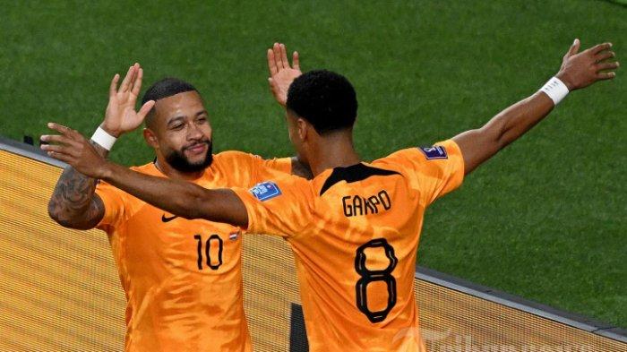 Penyerang Belanda Memphis Depay merayakan dengan rekan setimnya Cody Gakpo setelah mencetak gol pertama timnya selama pertandingan sepak bola babak 16 besar Piala Dunia Qatar 2022 antara Belanda dan AS di Stadion Internasional Khalifa di Doha pada 3 Desember 2022.