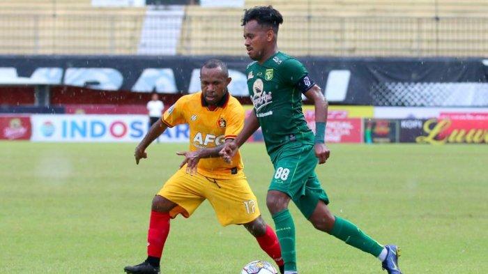 Pemain Persebaya Surabaya Alwi Slamat dijaga ketat pemain Persik Kediri Ferinando Pahabol musim lalu.