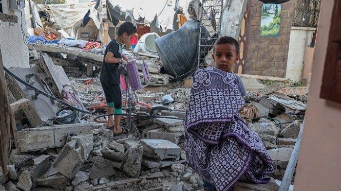 Sejumlah anak-anak mencari barang-barang dari puing-puing rumah mereka yang hancur terkena rudal jet tempur Israel di Kota Rafah, Jalur Gaza selatan, Palestina, Senin (8/8/2022)