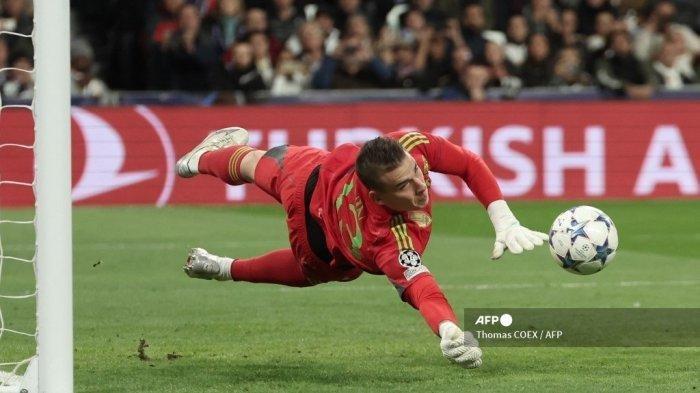 Penjaga gawang Real Madrid Ukraina #13 Andriy Lunin menghentikan bola selama pertandingan sepak bola grup C Liga Champions UEFA antara Real Madrid CF dan SC Braga di stadion Santiago Bernabeu di Madrid pada 8 November 2023.