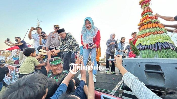 Bupati Klaten Sri Mulyani membagikan hasil bumi dari gunungan pada Festival Candi Kembar ke-lima yang digelar di Timur Candi Plaosan, Desa Bugisan, Kecamatan Prambanan, Klaten, pada Sabtu (7/9/2024).