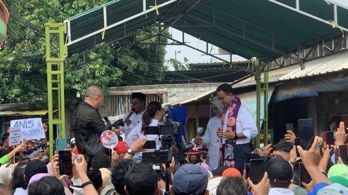 Capres nomor urut 1 Anies Baswedan dihadiahi selendang dan kotak celengan dari warga saat memulai kampanye hari pertama di Kampung Tanah Merah, Jakarta Utara.