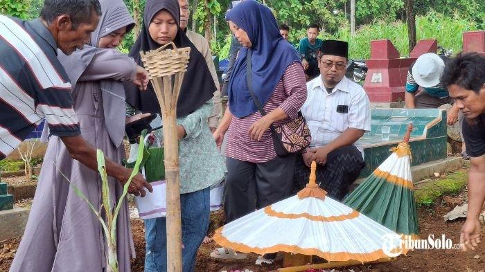 SUASANA DUKA : Pemakaman jenazah P (44) korban meninggal dunia dalam kecelakaan Batara Kresna vs Sigra di perlintasan Kelurahan Gayam, Kabupaten Sukoharjo, Rabu (26/3/2025). Saat dimakamkan, kedua anak korban mengantarkan hingga selesai