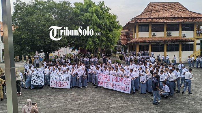 SISWA DEMO SEKOLAHNYA SENDIRI. Ratusan siswa kelas XII Sekolah Menengah Kejuruan Negeri (SMKN) 2 Solo ditemani wali murid gelar aksi demo di halaman sekolah, Senin (3/2/2025) siang. Keterlambatan pengisian data pendaftaran PPDS mengancam para siswa yang duduk di bangku kelas XII SMKN 2 Solo tak bisa masuk ke perguruan tinggi lewat jalur prestasi.