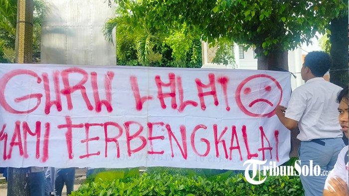 SISWA DEMO SEKOLAHNYA SENDIRI. Siswa Sekolah Menengah Kejuruan Negeri (SMKN) 2 Solo memasang spanduk bernada protes di halaman sekolahnya, Senin (3/2/2025) siang. Aksi protes dan demo ini buntut dari dugaan pihak sekolah tak menyelesaikan finalisasi Pangkalan Data Sekolah dan Siswa (PDSS) yang berujung siswa tak bisa mendaftar Seleksi Nasional Berbasis Prestasi (SNBP) menuju perguruan tinggi.