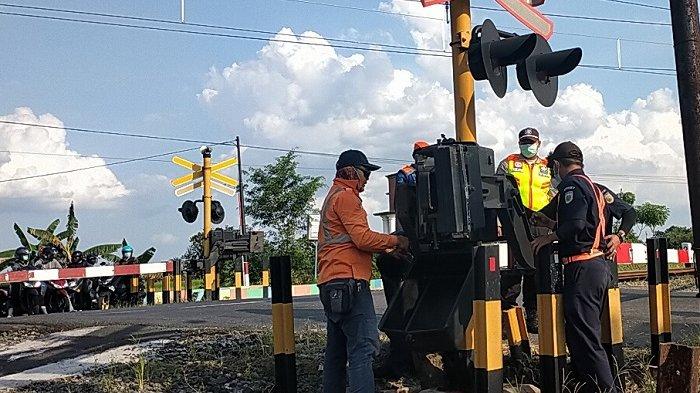 PALANG PINTU KERETA. Petugas memperbaiki palang pintu yang ditabrak pengendara di kawasan Pakis, Kecamatan Wonosari, Kabupaten Klaten, Selasa (27/4/2021). Ini terkait dengan upah petugas palang pintu yang masih menerima honor dinilai jauh dari layak.