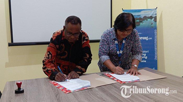 Kadis Pendidikan Tambrauw Yosep Yewen bersama GM bisnis Tribun area Papua Marina Napitupulu sedang tanda tangan MoU, Kota Sorong, Sabtu (27/1/2024).