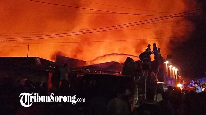 Petugas damkar lintas instansi di Kota Sorong bersama masyarakat bahu membahu memadamkan api yang malahap lapak-lapak di Pasar Remu, Sabtu (28/9/2024) malam.
