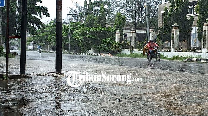 HUJAN DI KOTA SORONG - Pengendara mengenakan jas hujan melintas di Jalan Pramuka, Remu, Kota Sorong, Papua Barat Daya, Minggu (22/6/2025). BMKG memprakirakan seluruh wilayah di kabupaten/kota se-Papua Barat Daya diguyur hujan ringan disertai tingkat kelembapan udara yang tinggi dan suhu yang relatif stabil.