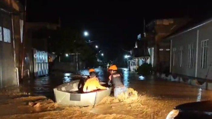 Petugas dari BPBD Kabupaten Mamuju yang sedang melewati banjir dengan perahu karet di Desa Bambu, Mamuju, Minggu (26/1/2025).