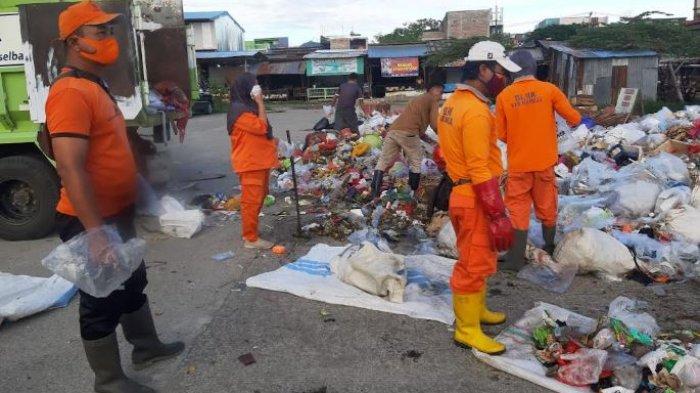 Petugas kebersihan yang sedang mengangkut sampah ke atas truk di Pasar Baru Mamuju, Jl Abdul Syakur, Karema, Mamuju, Sulawesi Barat, Senin (15/4/2024) pagi.