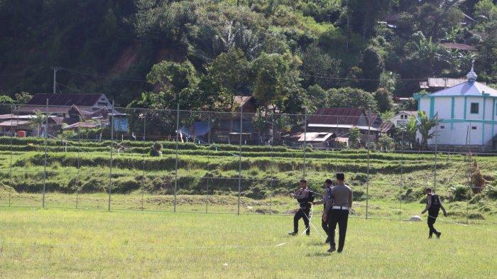 Polisi mengukur lapangan Lambanan yang akan dijadikan tempat mendarat helikopter Presiden Jokowi di Mamasa