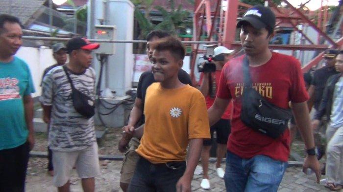 Polisi saat mengamankan pemuda bernama Tolleng (baju orange) usai memanjat menara tower di Kelurahan Polewali, Kecamatan Polewali, Polman, Minggu (19/11/2023) kemarin.
